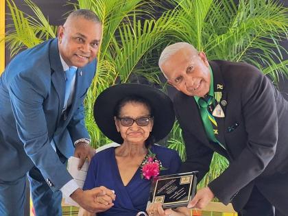 Eighty-eight-year-old Merle Stern, the oldest recipient at Monday’s National Heroes’ Day Salute Parade and Awards Ceremony, is pictured with her son, politician Michael Stern (left), and Councillor Winston Maragh, former mayor of May Pen.