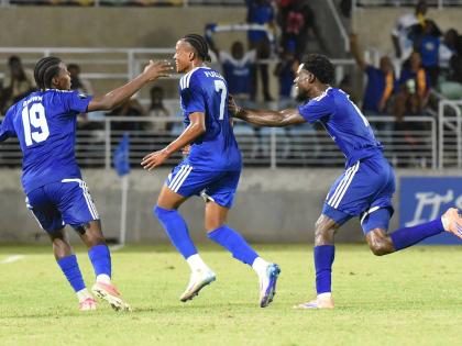 Mount Pleasant’s Nickalia Fuller (centre) celebrates with teammates Warner Brown (left) and Kyle Ming after scoring in yesterday’s Caribbean Cup semi-final football match against Trinidad and Tobago’s Club Sando at Sabina Park.