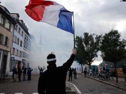 A protester holds a French flag during a demonstration against rising living costs in Strasbourg, France.