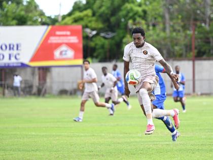 Chapelton Maroons’ Damoi Whitfield runs away from chasing Portmore United players during their Legend Jamaica Premier League fixture at Ferdi Neita Park yesterday. The game ended 0-0.