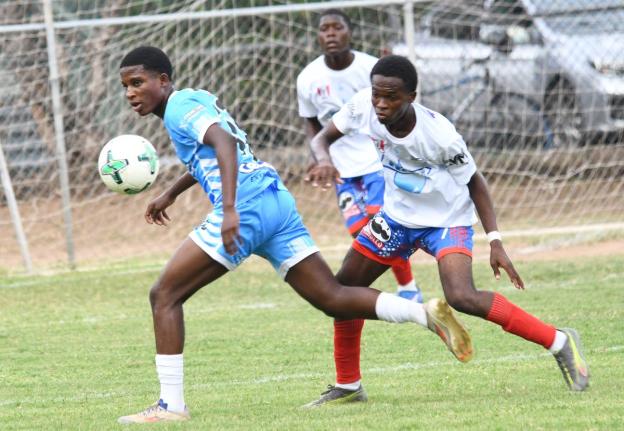 Ryland Fray-Campbell (left) of St George’s College moves away from Oniel Nelson of Holy Trinity during their Manning Cup Zone A match at Winchester Park yesterday. St George’s won 3-1.