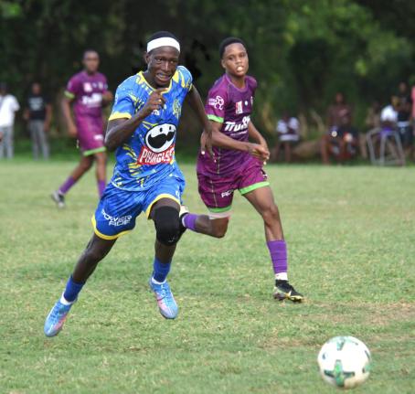 Cedric Titus High’s Terron Eccleston (left) dribbles away from William Knibb Memorial High’s Jaheem Brown (right) during their Zone D match in the ISSA daCosta Cup at William Knibb’s playing field yesterday. Ecclestion scored twice in his team’s 2-
