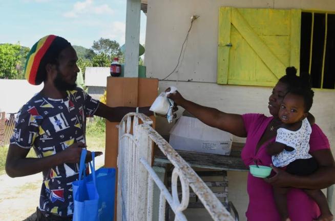 Gavin James buys a packet of flour from shopkeeper Ann Marie Cawley in St Elizabeth, Jamaica, May 17, 2021. 