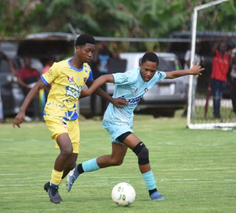 
St Elizabeth Technical High School’s Raheim Whyte (left) tries to stave off the challenge of Lacovia High’s Javier Clacken during their ISSA daCosta Cup Zone E football match at the STETHS Sports Complex yesterday.