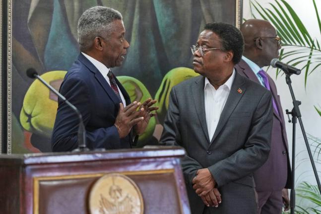 Chief of Protocol of the National Palace Marc Marie Yves Mazile speaks to Fritz Alphonse Jean, a member of Haiti’s transitional presidential council, before the start of a press conference in Port-au-Prince, Haiti, Tuesday, November 25, 2025.