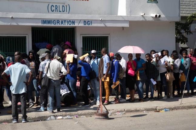
In this 2023 photo people line up outside an immigration office as they wait their turns to apply for a passport, in Port-au-Prince, Haiti.