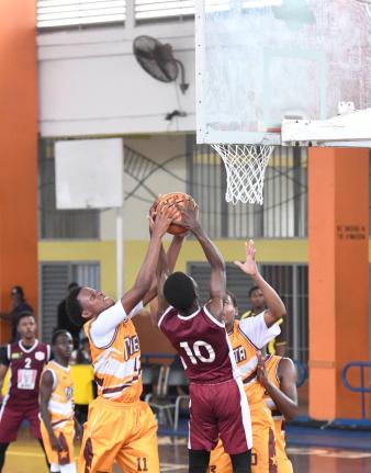 Andra Morgan (left) of Manchester High School  moves to block a shot by Antonio Kerr of Herbert Morrison during their ISSA Rural basketball Under-16 finals at GC Foster College yesterday.