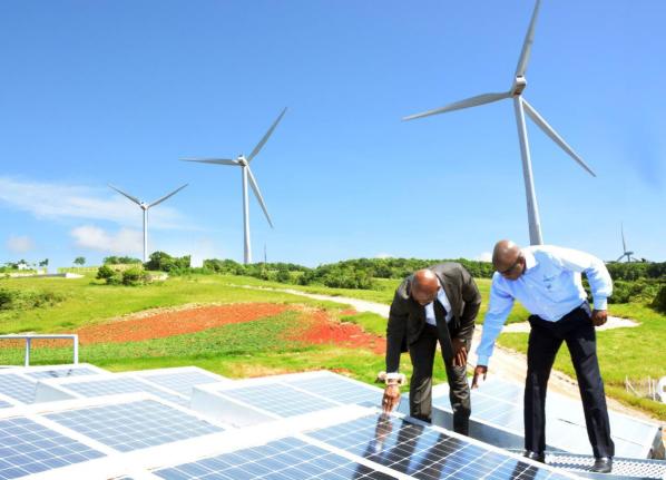 In this November 2, 2016, then Energy Minister Dr Andrew Wheatley, (left) and then Chairman of Wigton Windfarm Duane Smith examine solar panels installed at the wind farm in Manchester.