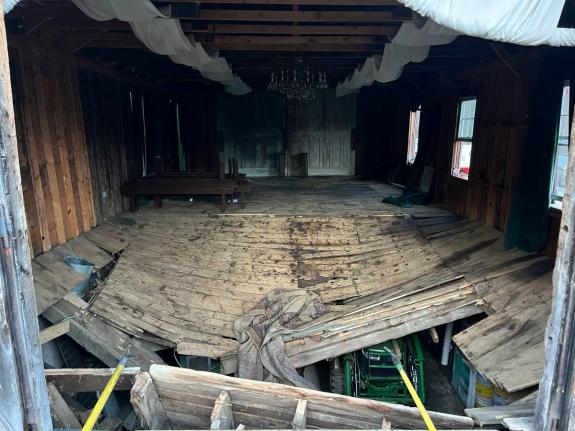 A photo provided by the New Hampshire State Fire Marshal's Office shows the buckled floor that collapsed Saturday, sending nearly 70 wedding guests into the basement of a building in Tamworth, N.H. Saturday, March 21, 2026. Six people were taken to the hos