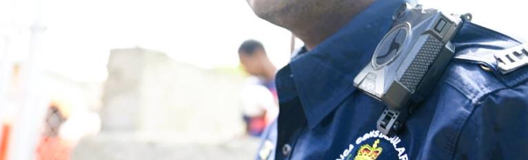 A member of the JCF is seen wearing a body-worn camera.