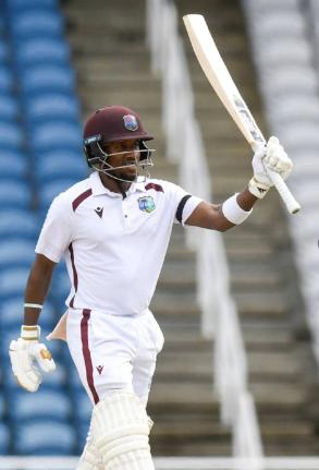 CWI Photo 
West Indies batsman Kavem Hodge raises his bat in celebration of a half-century on yestrday’s day one of a two-Test series against Pakistan at the Brian Lara Cricket Academy in Tarouba, Trinidad and Tobago yesterday.