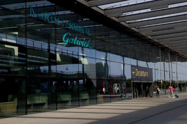 Passengers walk into the Departures entrance at the North Terminal of Gatwick Airport near Crawley, just south of London, on July 22, 2020. (AP Photo/Matt Dunham, File)