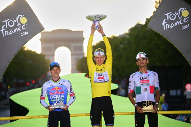 Slovenia’s Tadej Pogacar, wearing the overall leader’s yellow jersey, celebrates on the podium after winning the Tour de France cycling race alongside Belgium’s Remco Evenepoel, second, and Mexico’s Isaac Del Toro, third, in Paris, yesterday.