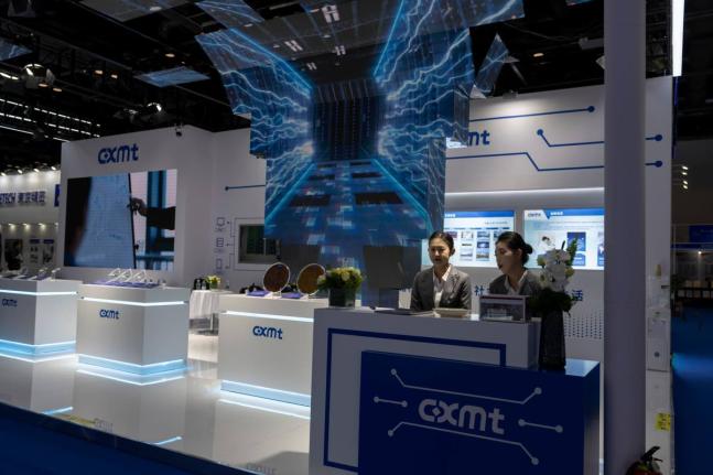 FILE - Workers at the booth for Chinese DRAM producer ChangXin Memory Technologies, also known as CXMT, wait for visitors at the 21st China International Semiconductor Expo in Beijing, Nov. 20, 2024. (AP Photo/Ng Han Guan, File)