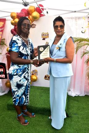 Janet Clarke (left), principal, Tidy Tots Educare in Black River, St Elizabeth, makes a presentation to Susan Holness (right), chief – new business and underwriting, JN Life Insurance, during the school’s recent graduation ceremony which was held at th