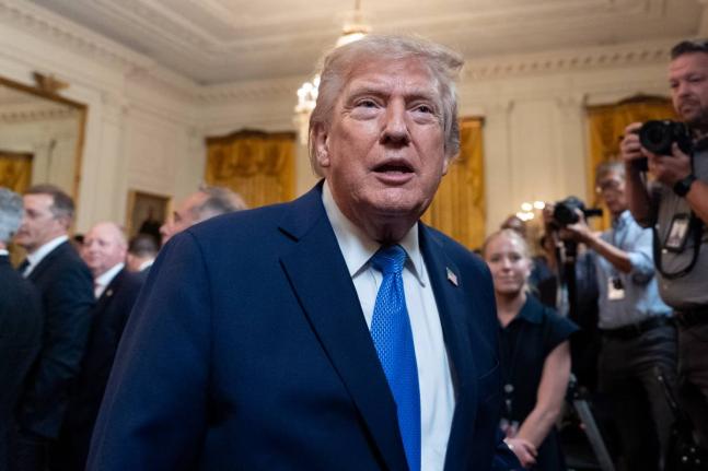 President Donald Trump speaks with a reporter as he departs after an event for Olympic athletes, coaches, staff, and representatives from Team USA in the East Room of the White House, Thursday, Aug. 6, 2026, in Washington. (AP Photo/Alex Brandon)