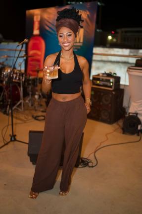Trishana Williams, financial service representative, holds her Appleton Estate Spanish Sherry cocktail in hand, dressed in casual chocolate brown slacks, a matching head scarf, and a black halter.