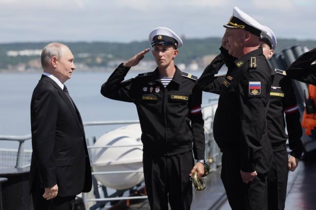 Russian President Vladimir Putin, left, visits the Varyag missile cruiser of the Pacific Fleet to watch a military exercise near Yuzhno-Sakhalinsk, on Sakhalin Island, Russia, Wednesday.