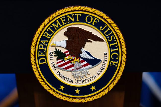 FILE - The U.S. Department of Justice logo is seen on a podium before a news conference, May 4, 2026, in Washington. (AP Photo/Julia Demaree Nikhinson, File)
