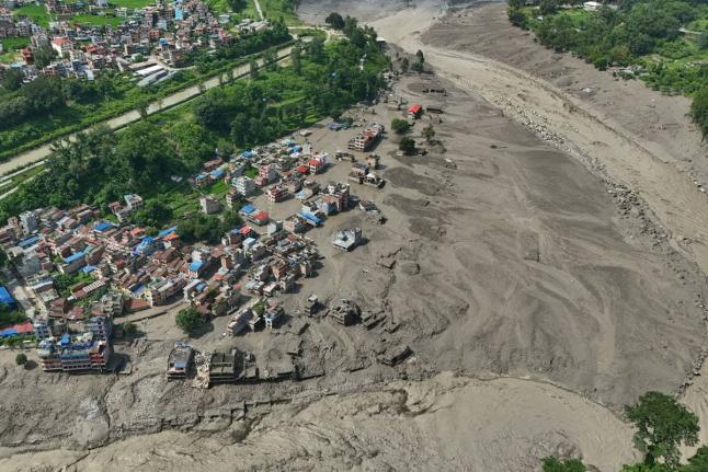 Damaged houses stand precariously near the swollen, debris-choked banks of the Trishuli River after flash floods in Nepal's Nuwakot district on Wednesday. - AP photo