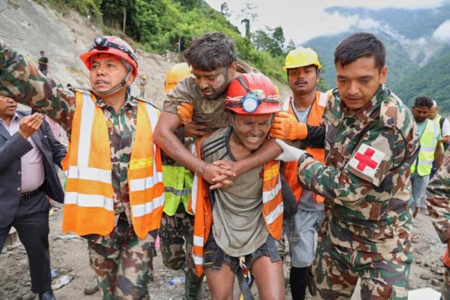 In this photo provided by the Nepal Army, soldiers rescue a worker alive from a tunnel during an ongoing operation at the Trishuli-3A hydropower project in Nepal's Rasuwa district on Friday. - AP photo
