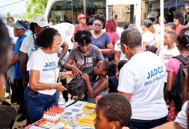 June Spence Jarrett, executive director of the Jamaica Anti-Doping Commission (JADCO), presents a school bag and other school supplies to a child at JADCO’s back-to-school treat held at the Siloah New Testament Church of God in St Elizabeth on August 29.