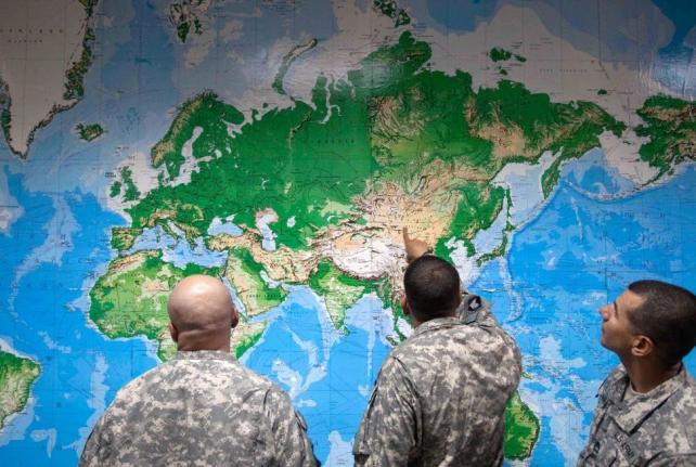 Soldiers look at a world map as they wait to board a flight in Manas, Kyrgyzstan, on the way home after completing a deployment in Afghanistan, Thursday, August 11, 2011. (AP Photo/David Goldman, file)