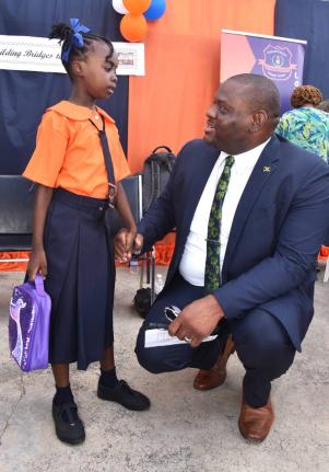 Parliamentary Secretary in the Ministry of Education, Skills, Youth and Information, Senator Marlon Morgan, greets student of Edward Seaga Primary School in Kingston, Ajonieke Whittingham, during a visit to the institution's North Street campus on Monday, 