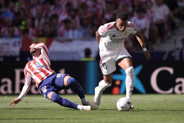 Atletico Madrid’s Alex Baena (left) falls to the ground in a clash with Real Madrid’s Kylian Mbappe during a Spanish La Liga football match in Madrid on Sunday.