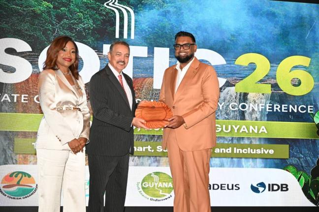 Guyana President Dr Mohamed Irfaan Ali (right) accepts a gift from new Chairman of the Caribbean Tourism Organization, Antigua and Barbuda’s Minister of Tourism, Charles Fernandez, while Secretary General and CEO of the CTO, Dona Regis-Prosper shares in 