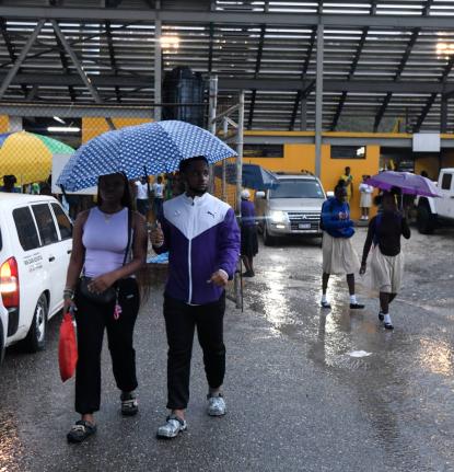 Kingston College supporters leave the Stadium East yesterday after the opening Walker Cup KO semi-final between Excelsior High and Kingston College was halted by heavy rain at the venue. 