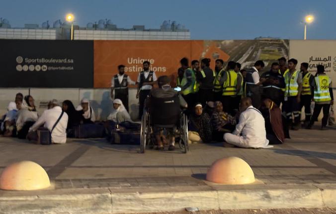 People gather outside a metro station on the road to King Khalid International Airport in Riyadh, Saudi Arabia