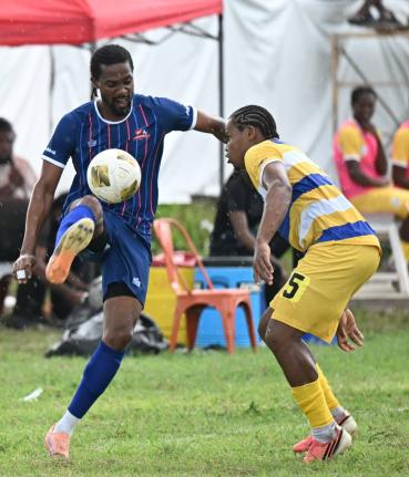 Dunbeholden’s Nevaun Turner (left) controls the ball while under pressure from Molynes United’s Raje Ximines during yesterday’s Jamaica Premier League match at Dunbeholden. 