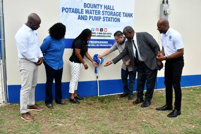 Minister of Water, Environment and Climate Change, Matthew Samuda (third right), turns on a tap to officially commission the upgraded Bounty Hall Water System in Trelawny on October 8. Joining him are (from left) National Water Commission (NWC) Regional Ma