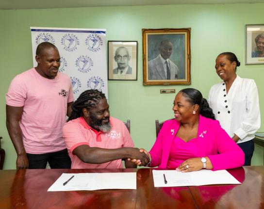 NOON Brunch Series director Adrian Heron shakes hands with Jamaica Cancer Society Executive Director Roshane Reid-Koomson following the signing of a memorandum of understanding, as fellow NOON director Dane Wilson and JCS Fundraising and Public Relations O