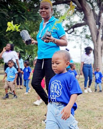 Marlene Graham-Hall, National Water Commission’s (NWC) senior customer relations manager for Kingston, St Andrew and St Thomas, walks with a student from the NWC Cooperative Credit Union Basic School in St Andrew during an activity at the institution for