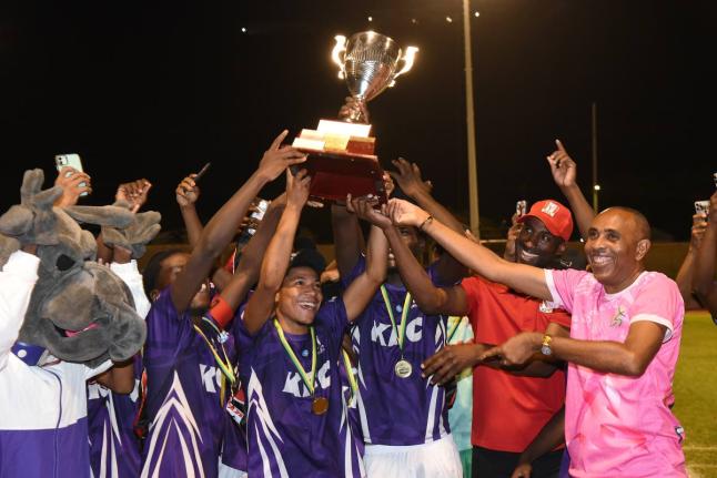 Keith Wellington (right), President of the Inter-Secondary Schools Association and Andrei Roper (second right) Marketing Manager, Restaurants of Jamaica, present the Walker Cup to the 2026 champions, Kingston College, shortly after they defeated Mona High 