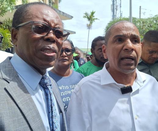 May Pen Mayor Joel Williams (left) listens as Clarendon Central Member of Parliament Delroy Williams is interviewed by journalists last Friday.
