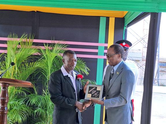 Television Jamaica’s Clarendon correspondent, Hopeton Henry accepts his award from May Pen mayor Councillor Joel Williams during the parish’s National Heroes Day salute parade and awards ceremony on Monday.