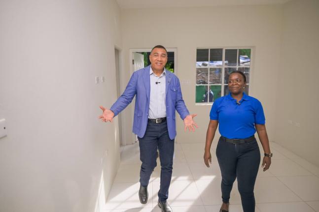 Prime Minister Dr Andrew Holness (left) tours a New Social Housing Programme (NSHP) unit in Greendale district, Bull Bay, with recipient Jodian Bernard on October 21.