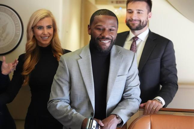 Floyd Mayweather, Jr., stands with White House press secretary Katie Zacharia, left, on Air Force One before a campaign rally with President Donald Trump at Laughlin Bullhead International Airport, in Bullhead, Arizona. 