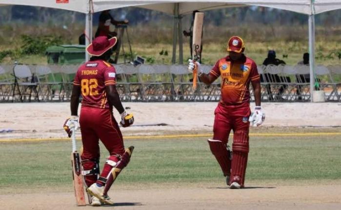 West Indies Over40 batsman Sewnarine Chattergoon (right) raises his bat in celebration of a half-century as Randy Thomas looks on.