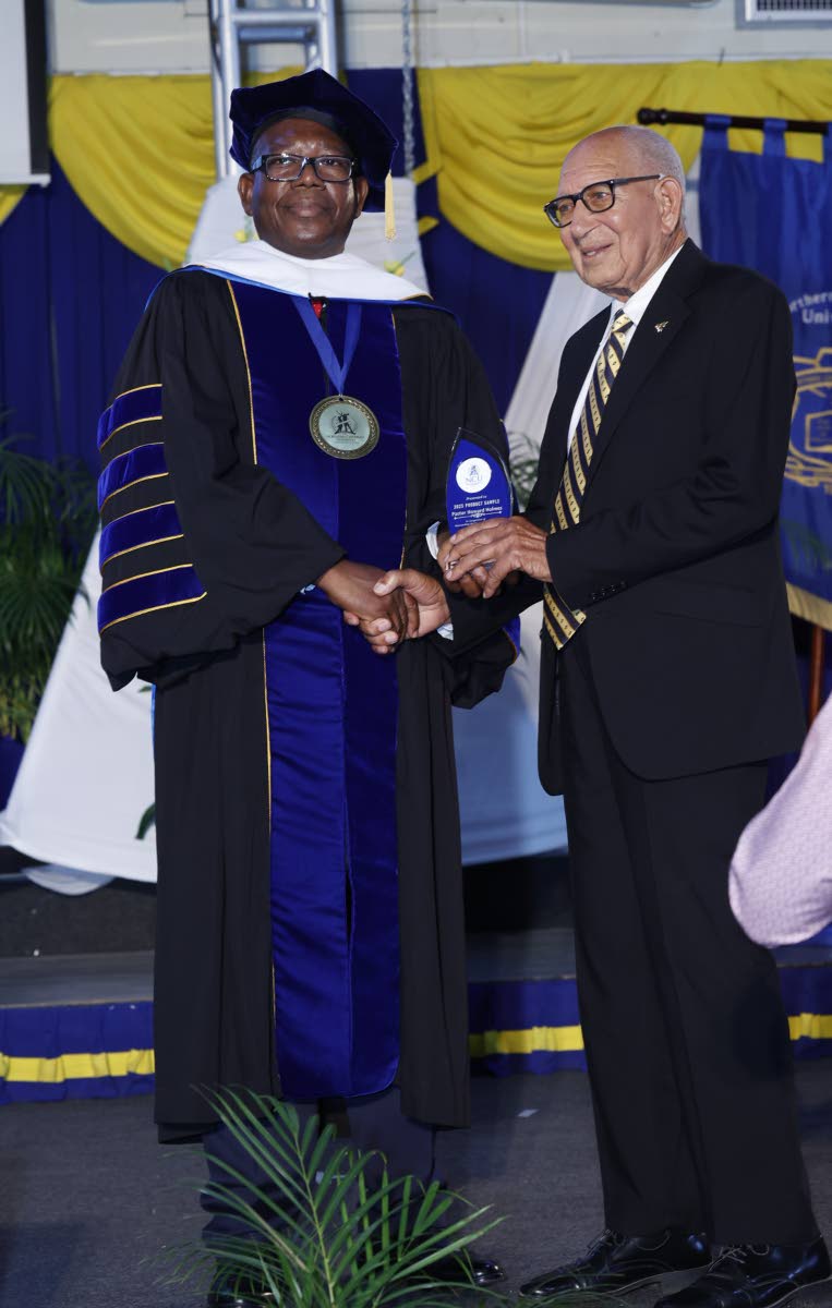 Professor Lincoln Edwards (left), president of Northern Caribbean University, presents the Product Sample award to Pastor Howard Holmes.