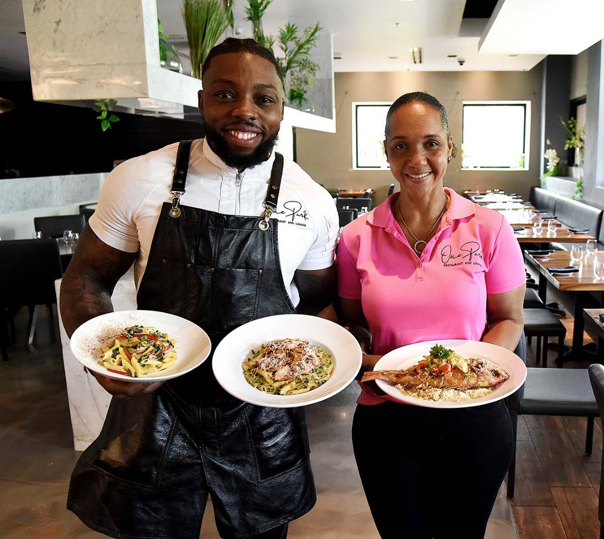 Executive Chef Judah Ellis and Patricia Myrie, one of the directors of One Park Restaurant and Lounge, pose proudly with the relief menu items (from left) Rasta pasta relief, island Alfredo, and island snapper fish.