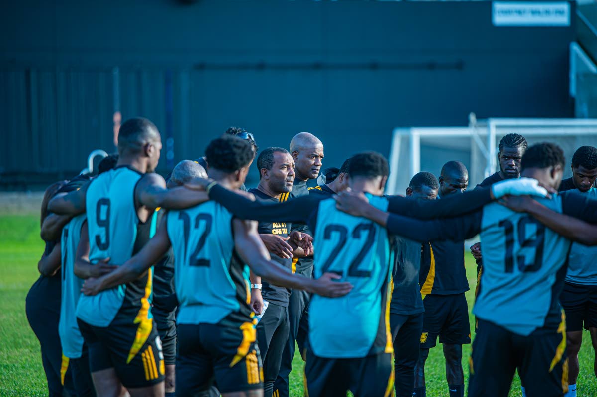 Reggae Boyz interim coach Rudolph Speid huddles with his charges during a training session at Sabina Park.