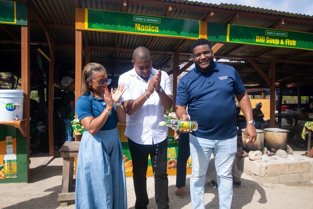 Samara South, public affairs and government relations manager at J. Wray & Nephew Limited; Floyd Green, Minister of Agriculture, Fisheries and Mining, applaud as Cecil Smith, commercial director at J. Wray & Nephew Limited, makes the customary pour of Wray