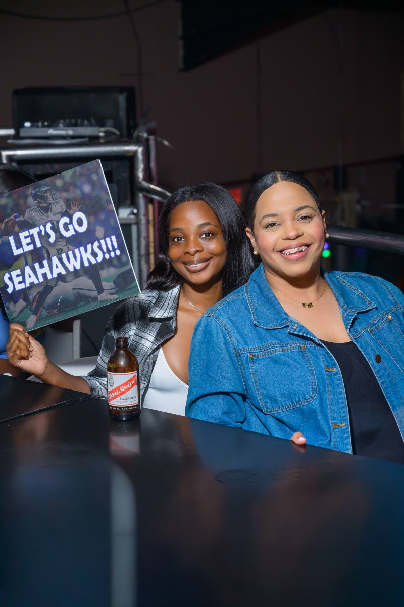 Cheering in support are Hanna Turner (left), Red Stripe junior brand manager, and Amoye Phillpotts-Brown, Red Stripe brand manager, as they show their support for the Seahawks.