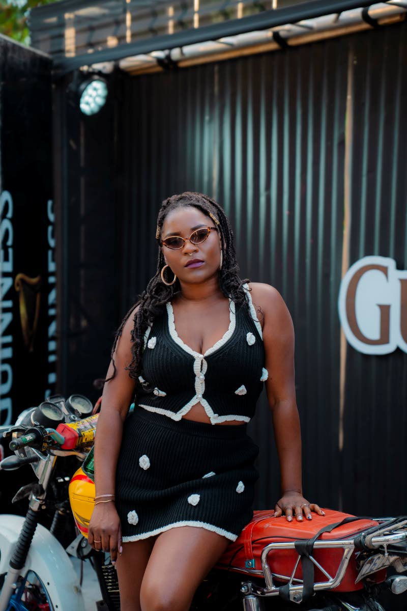 Recording artiste Emerald commands the frame in a black and white crochet mini skirt set, dotted with delicate floral details.