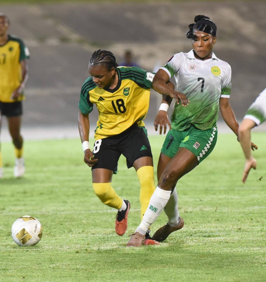 Reggae Girlz attacker, Trudi Carter tries to escape the attentions of Guyana’s Otesha Charles during their Concacaf W Qualifier inside the National Stadium on Saturday.