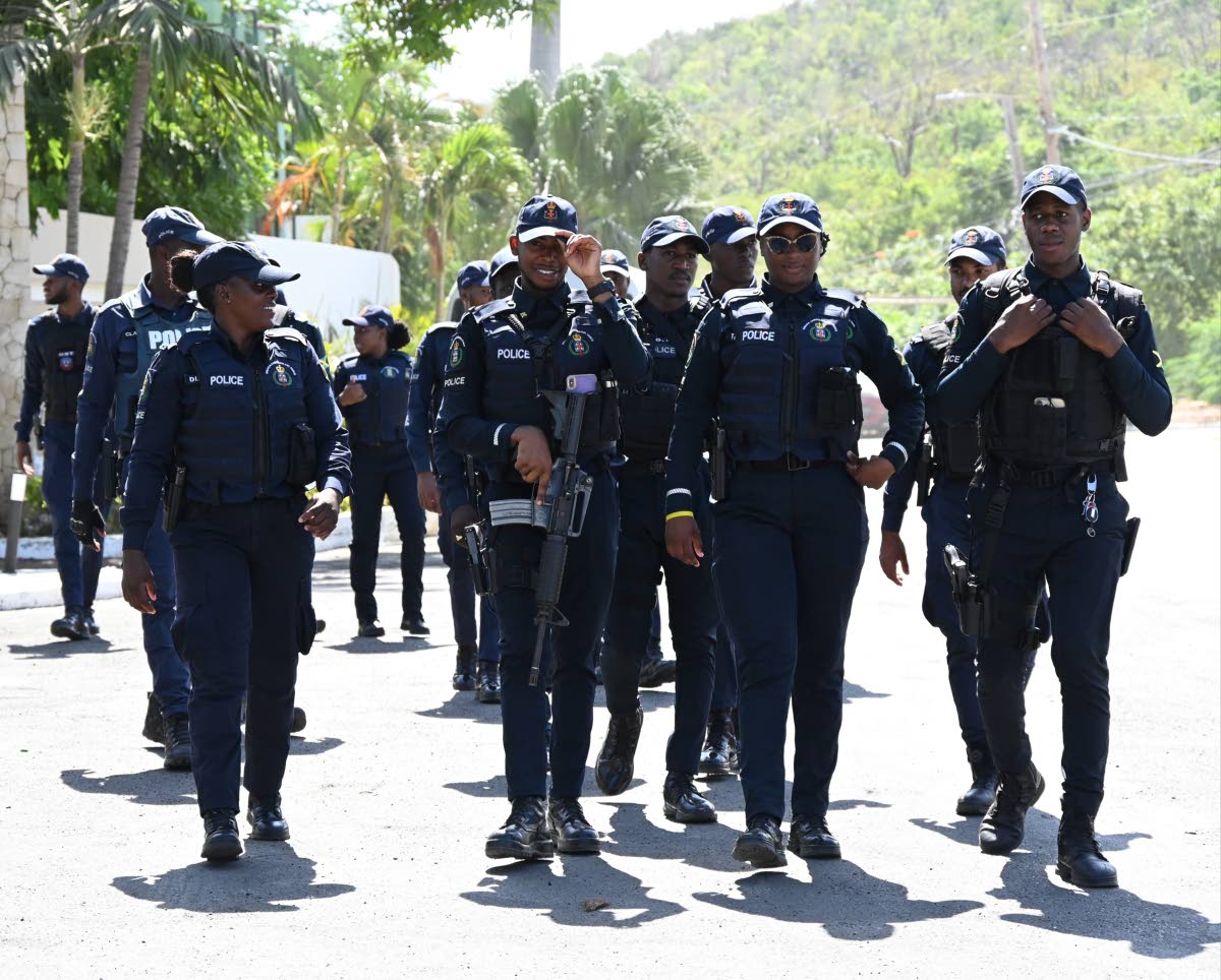 Members of the Jamaica Constabulary Force during a tour by Prime Minister Dr Andrew Holness who was visiting Coopers Pen in Trelawny yesterday.